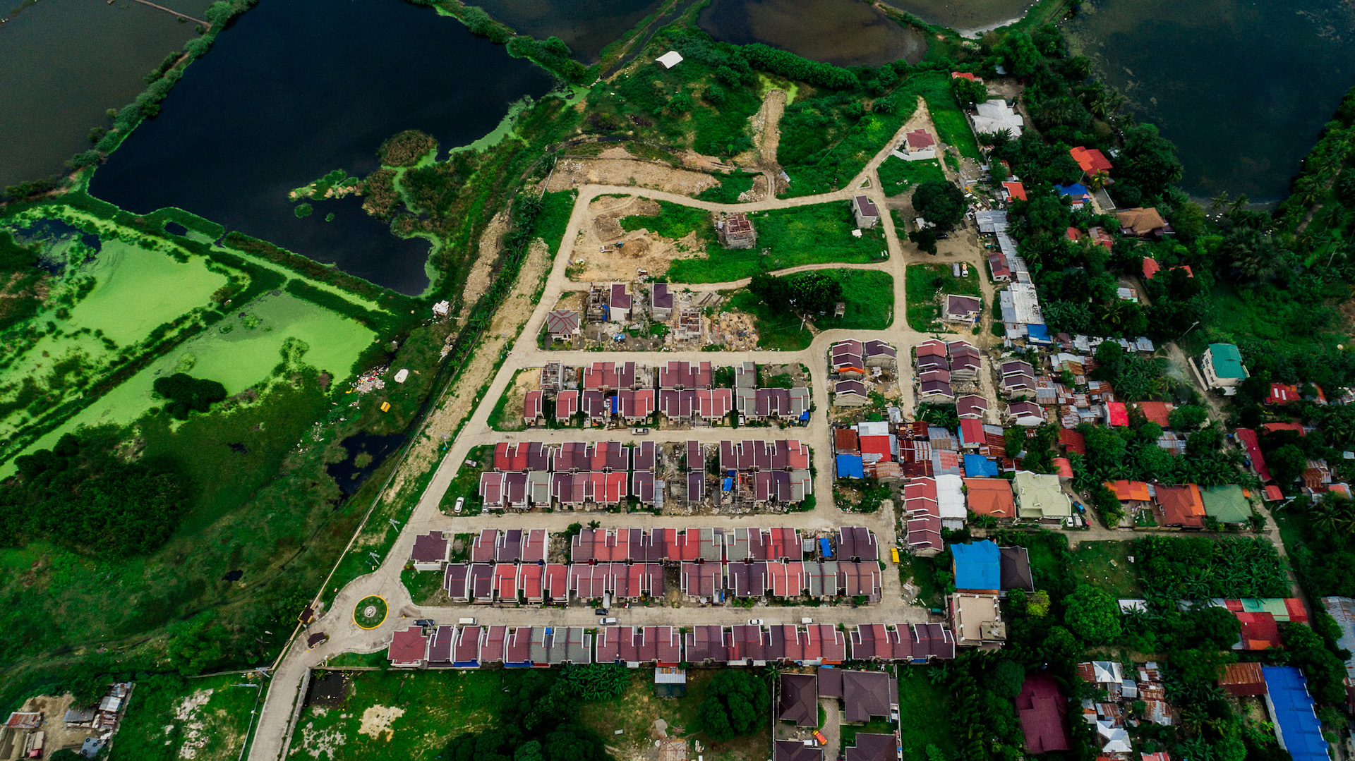 Wide aerial view of Anami Homes North set among greenery and water