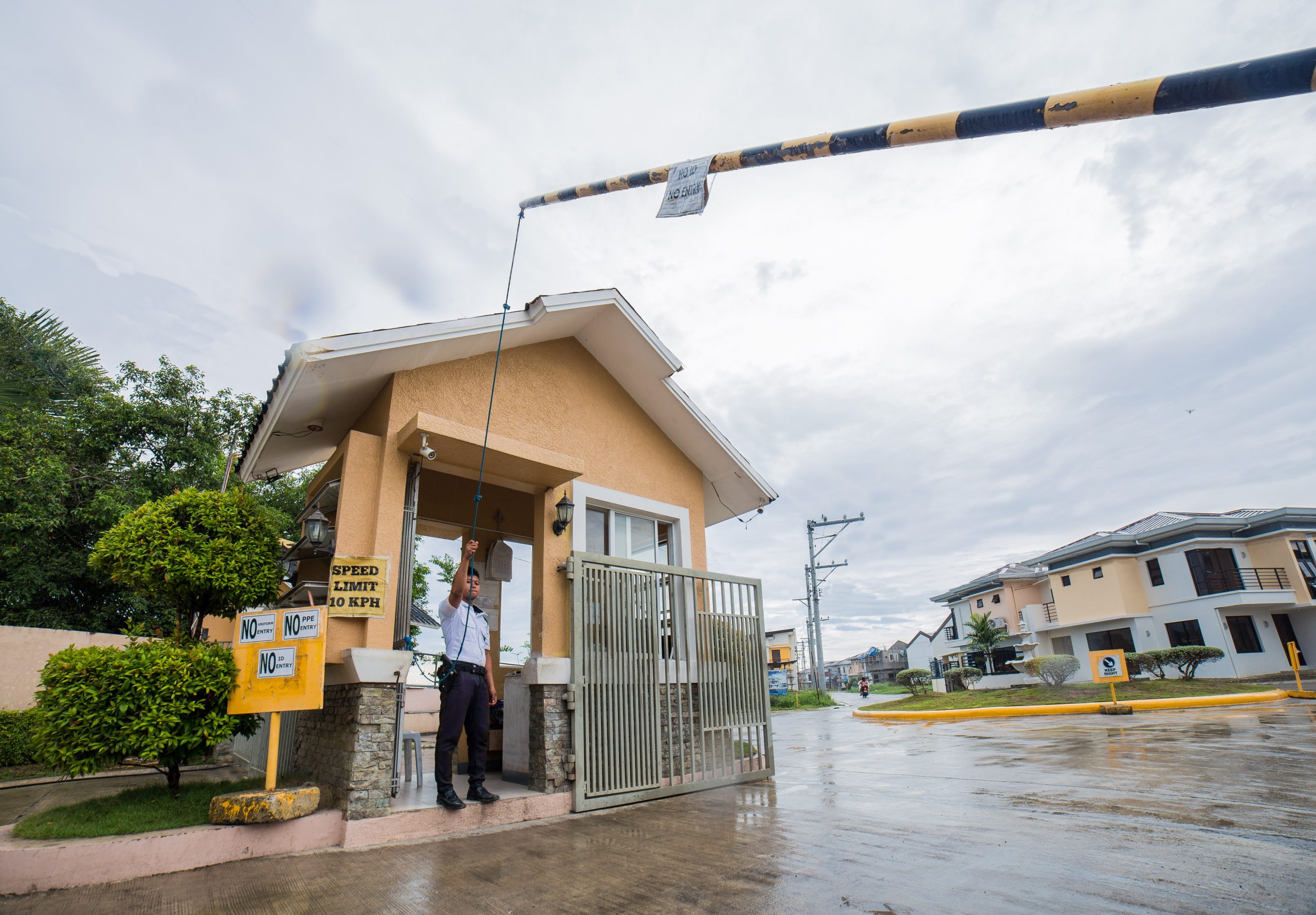 A guard at the barrier of the Anami Homes North entrance gate